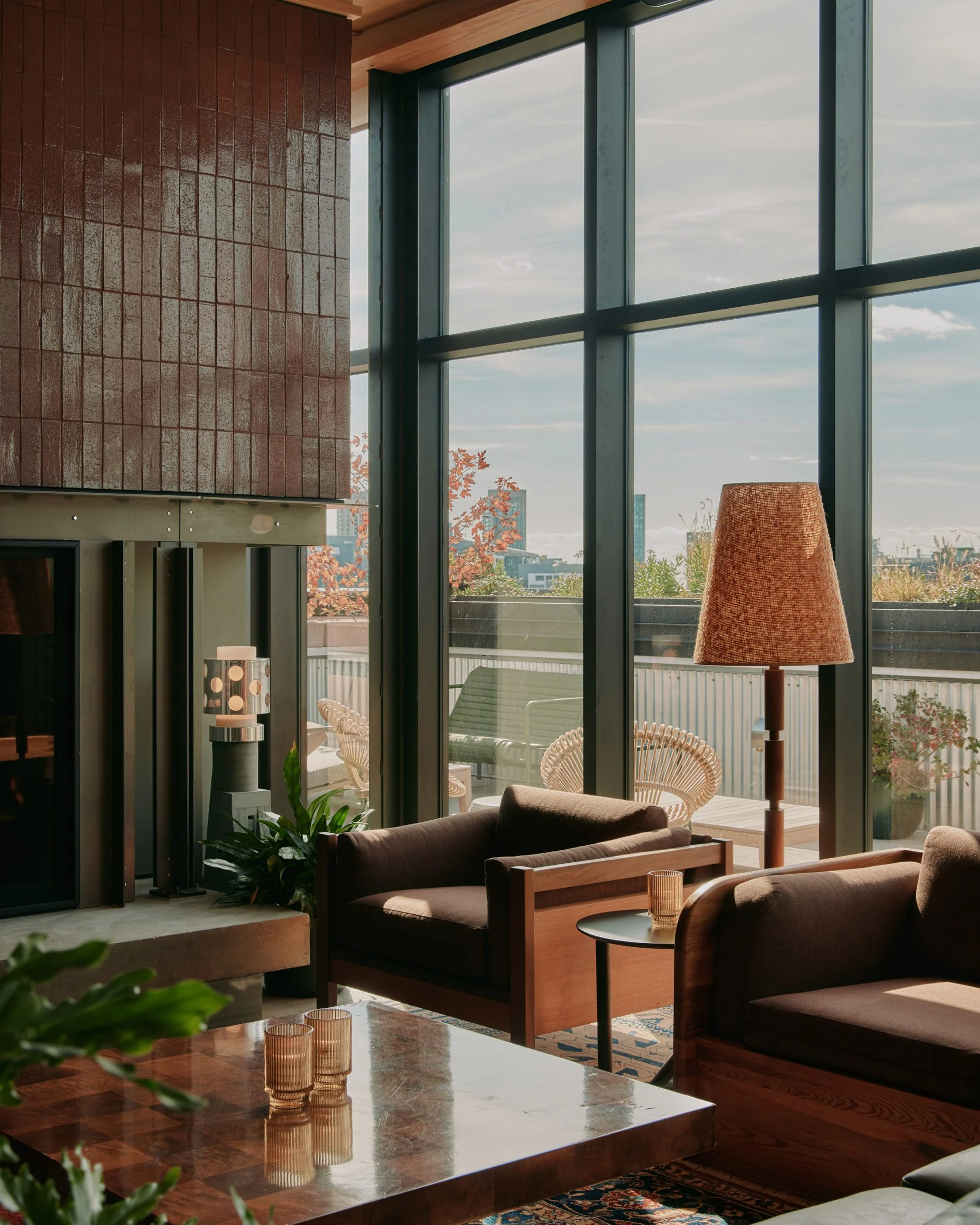 Large fireplaces bookend Evangeline rooftop bar at Ace Hotel Toronto